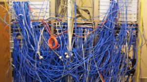 Стойка с запутанными сетевыми кабелями и коммутационными панелями — атака доходит до машин, у которых порт удалённого доступа открыт в интернет